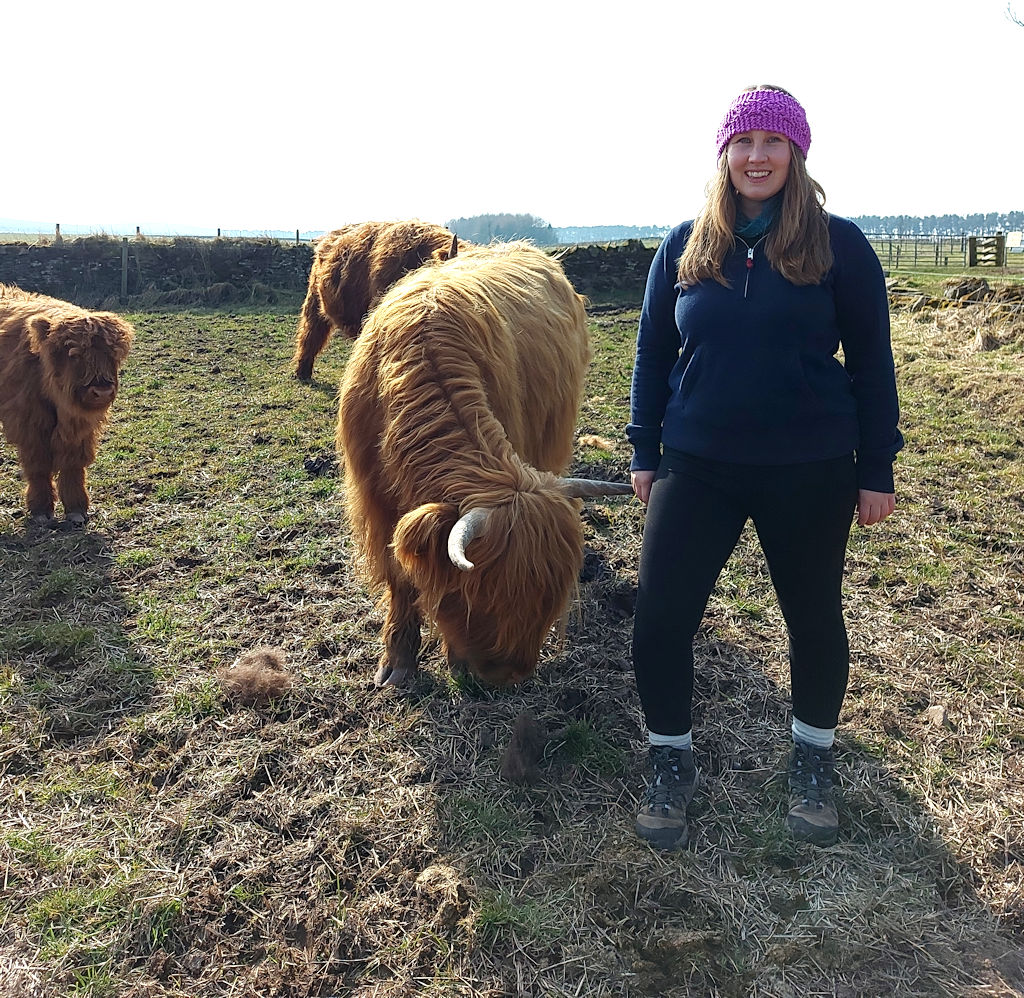 Sophie with Highland cows on the farm tour at Newton Farm in Angus